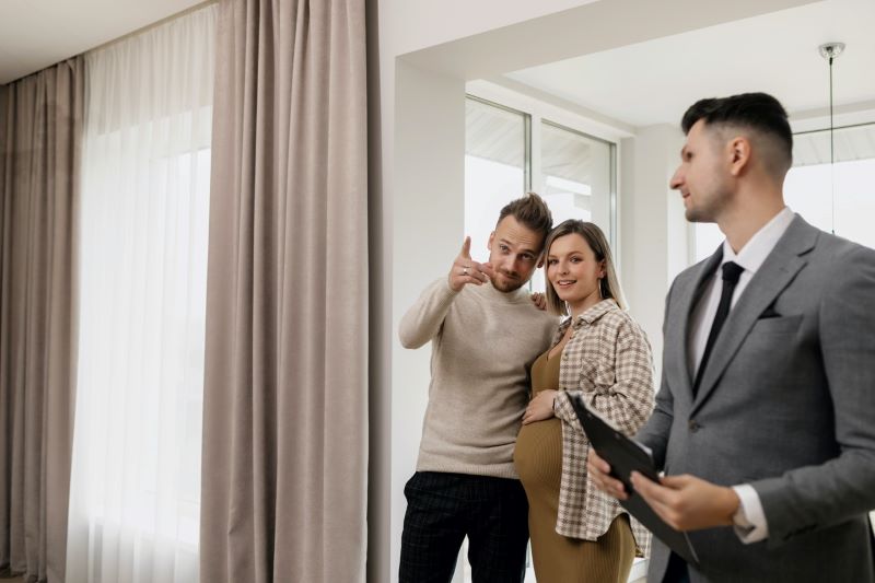 Man and expecting woman with male realtor at condo showing