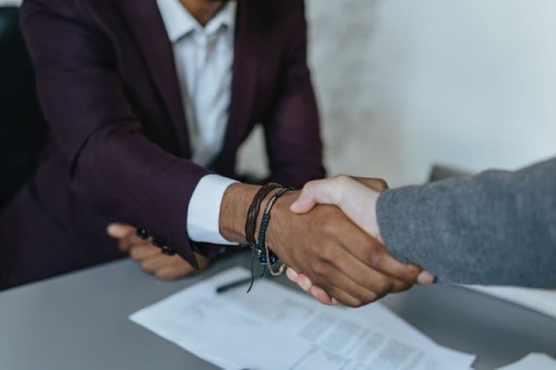 Male realtor shaking hands with male client