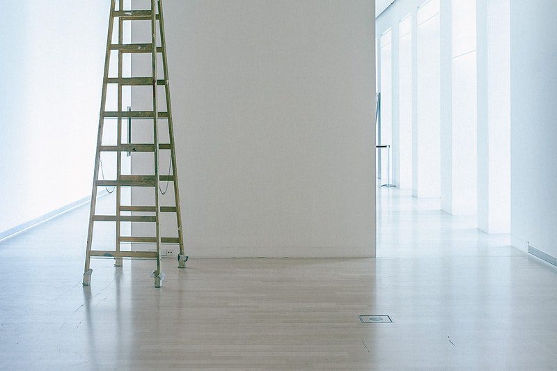 An empty room with a ladder against a wall
